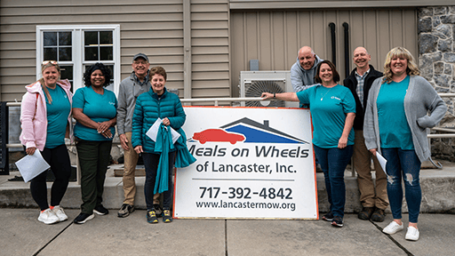 A group of Penlanco volunteers stand in front of the building.